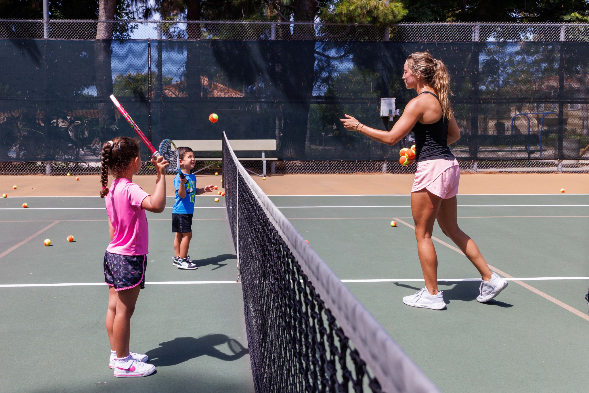 DB Tennis coach working with young players on court
