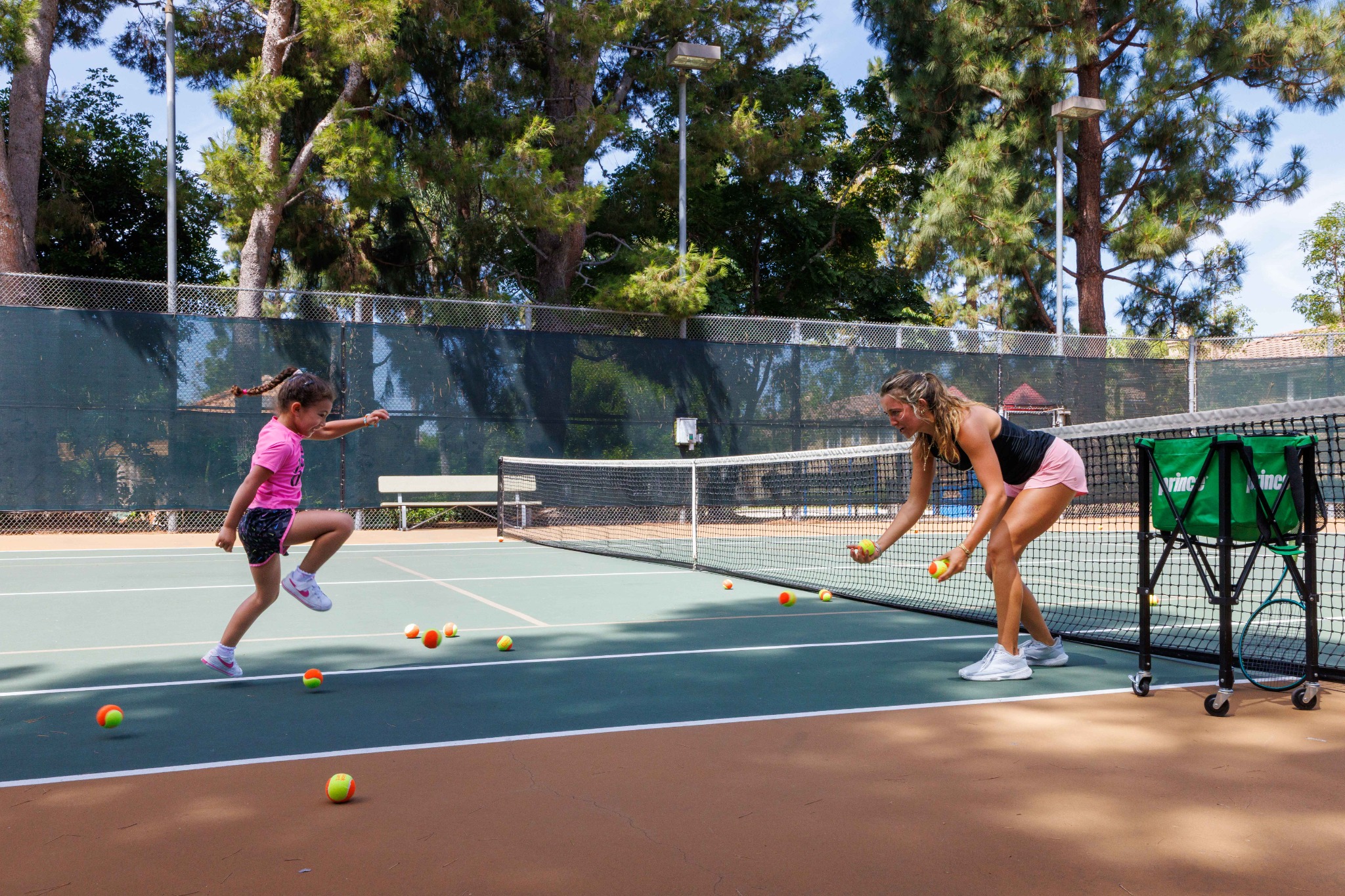 DB Tennis coach and child practicing on court